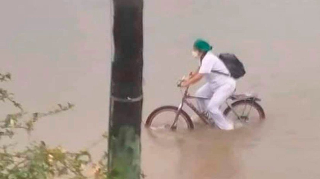 enfermera-en-bicicleta-cruza-calles-inundacion-en-bolivia.jpg